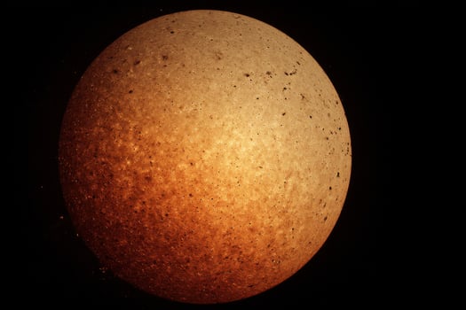 An orange and black sphere with a hole in it photo