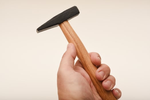 A small hammer with a wooden handle. A hammer on a white background in his hand. photo