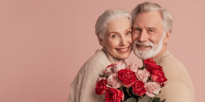 The joyful elderly couple with a bouquet of roses celebrating love and happiness. photo
