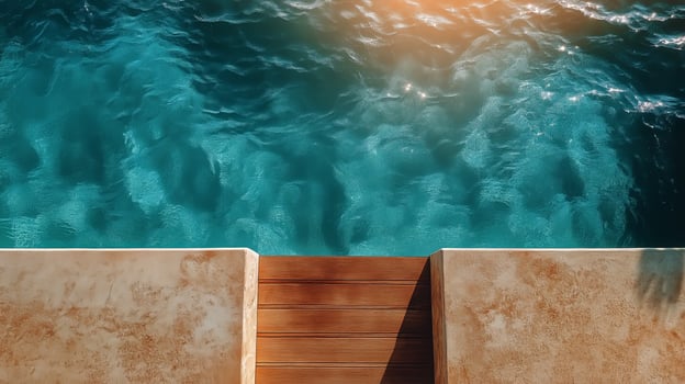 Serene Poolside View Capturing Sparkling Turquoise Water and Wooden Deck Under Sunlight photo