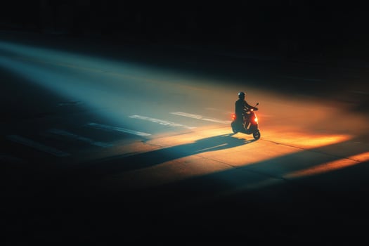 A person on a motorcycle is in the light photo