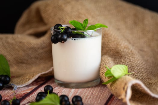 Natural yogurt with blackcurrant on a wooden table photo