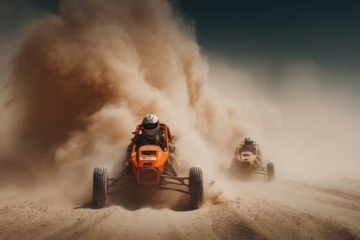 Two people riding on a dirt road with dust coming out of the vehicle photo