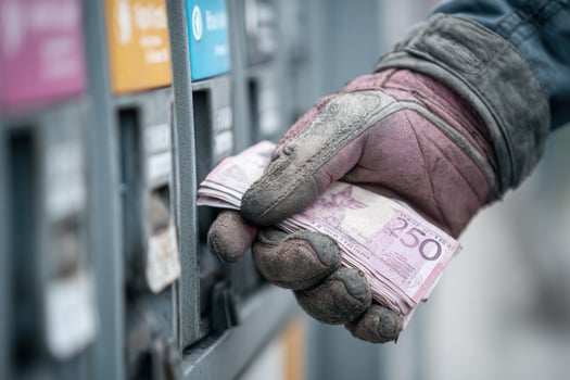 A person holding money from a gas pump photo