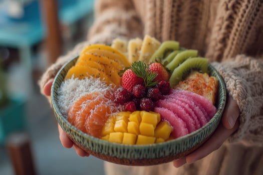 A person holding a bowl of fruit in their hands photo