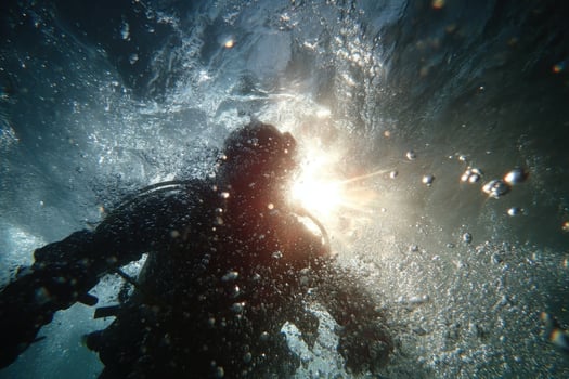 A person in a scuba suit swimming through water photo