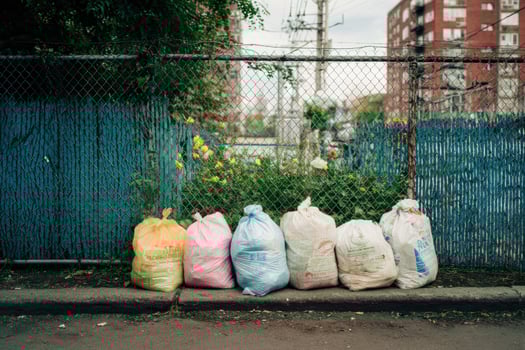 A group of garbage bags sitting on the side of the road photo