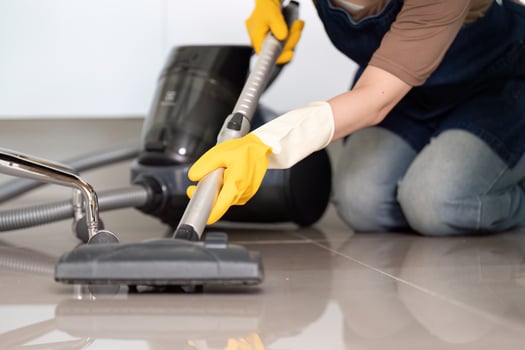 Floor Cleaning. Person vacuuming tiled floor with vacuum cleaner. photo