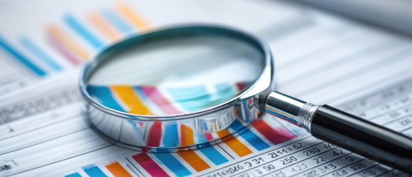 The magnifying glass revealing data trends in a business analysis report. photo