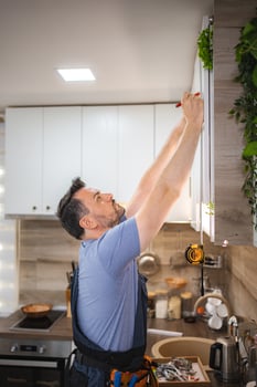 Carpenter working on a new kitchen furniture installation photo