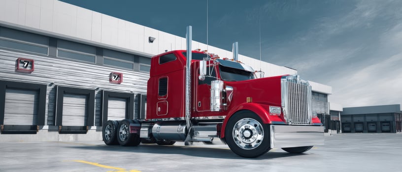 The powerful red truck parked near a modern industrial building photo