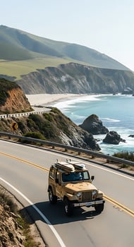 Tan jeep with surfboards driving on coastal highway with ocean and mountains in the background photo