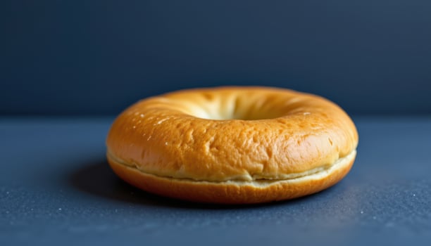 Freshly Baked Bagel on a Blue Background Perfect for Food Photography Projects photo