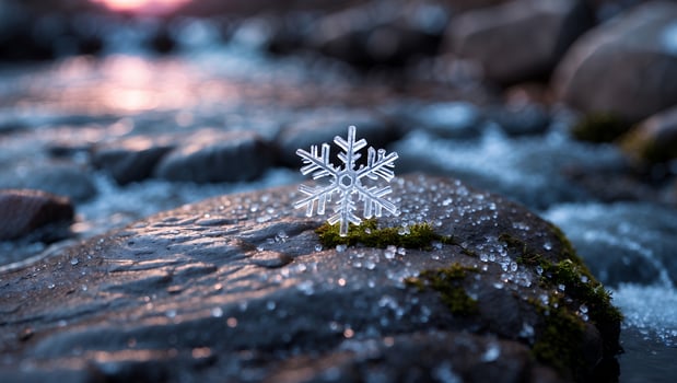 Snowflake Resting on Rock by Flowing River at Dusk Creating Winter Scene photo