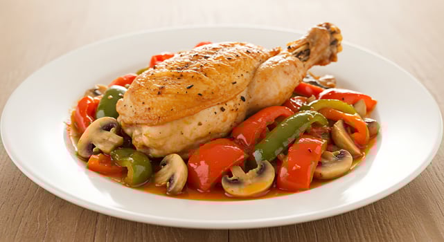 A white plate with chicken and vegetables photo