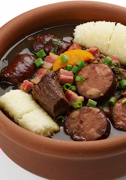 A bowl of food with meat, potatoes, and onions photo