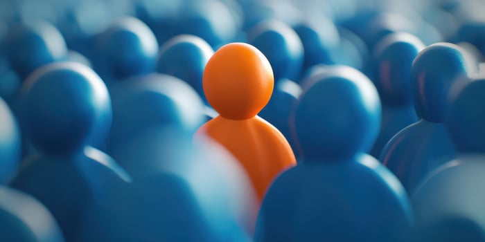 The Orange Figure Stands Out in a Blue Crowd Representing Individuality. photo
