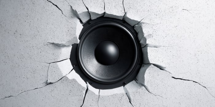 The speaker bursting through a cracked wall, showcasing powerful sound energy. photo
