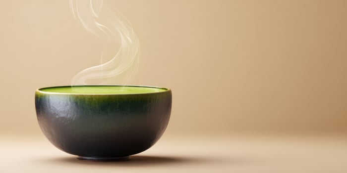The steaming bowl of green tea on a minimalist background. photo