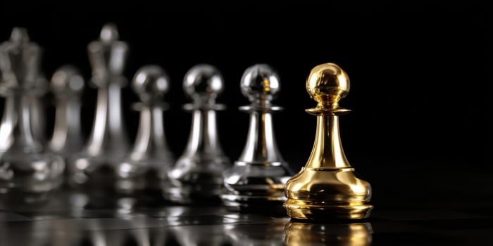 The golden pawn stands out among the shining chess pieces in contrast. photo