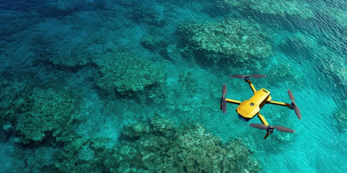 The drone flying over stunning coral reefs in clear blue ocean waters. photo