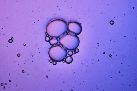 Bubbles in shampoo or shower gel. Texture on a purple background. photo