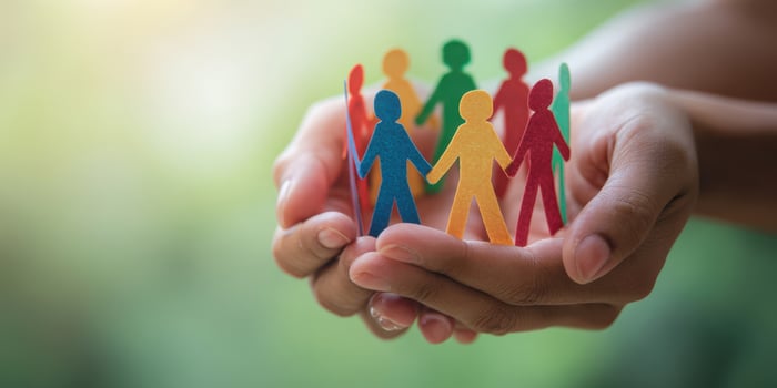The Hands Holding Colorful Paper Cutouts of Diverse People in Unity photo