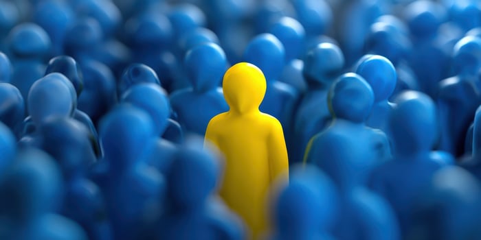 The Yellow Figure Standing Out Among Blue Crowd Representing Uniqueness photo