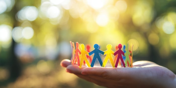 The colorful paper figures symbolizing unity and community in a hand. photo