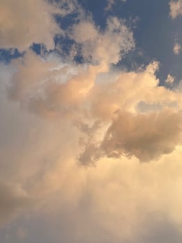 Vibrant clouds illuminated by warm sunset light, stunning sky scene filled with soft hues of orange, and gold. Peaceful and atmospheric nature background photo