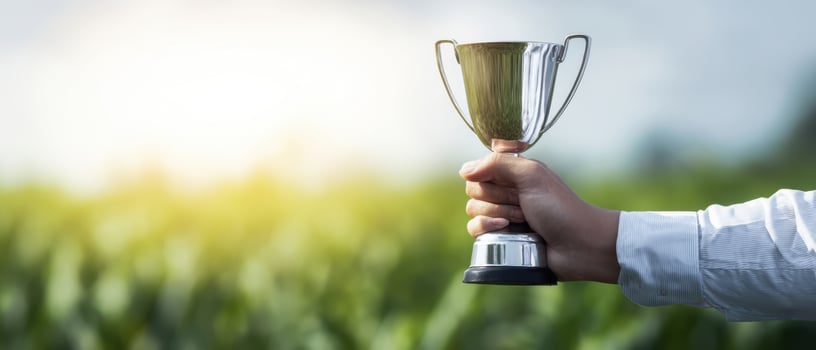The trophy held high against a beautiful green landscape, celebrating achievement. photo