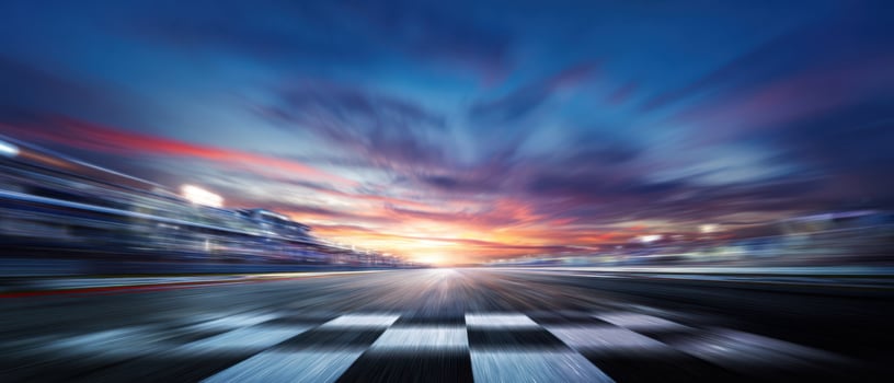The motion blur of a racetrack at sunset with a checkered finish line. photo