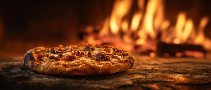 The delicious wood-fired pizza sizzling in front of a roaring fire. photo