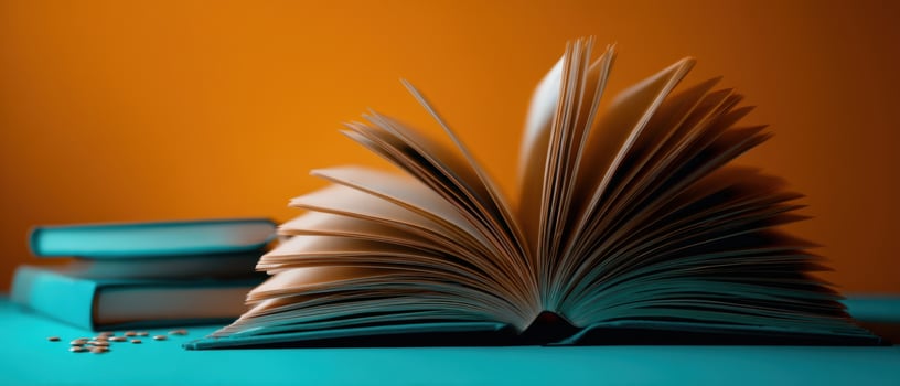 The open book revealing pages on a teal surface with a colorful backdrop. photo