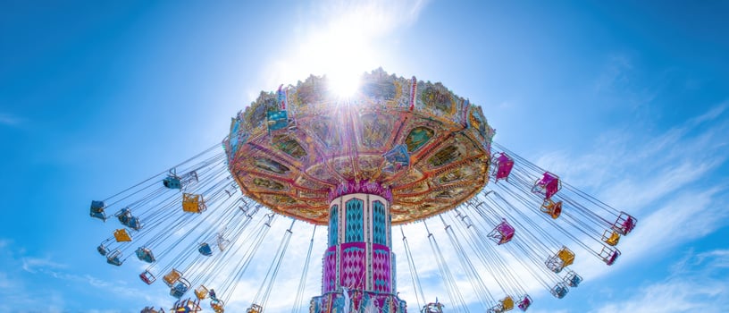 The colorful swing ride under a bright blue sky with radiant sunlight. photo