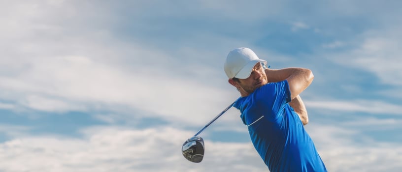 The golfer executing a powerful swing against a picturesque sky background. photo