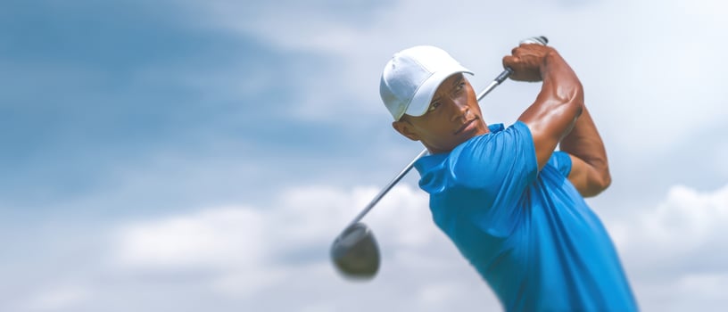 The athlete demonstrating a powerful golf swing against a clear sky backdrop. photo