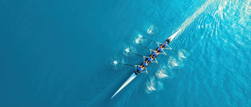 The rowing team navigating through vibrant blue waters with synchronized strokes. photo