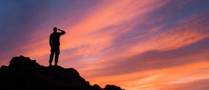 The silhouette of a man saluting against a stunning sunset backdrop. photo