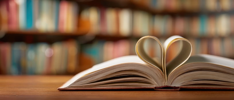 The book forming a heart shape on a wooden table in a cozy library setting. photo