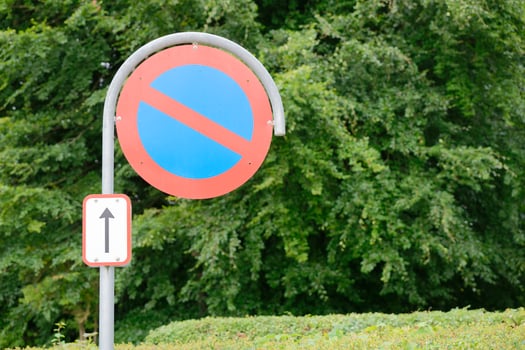 No Parking Sign with Arrow in Green Setting photo