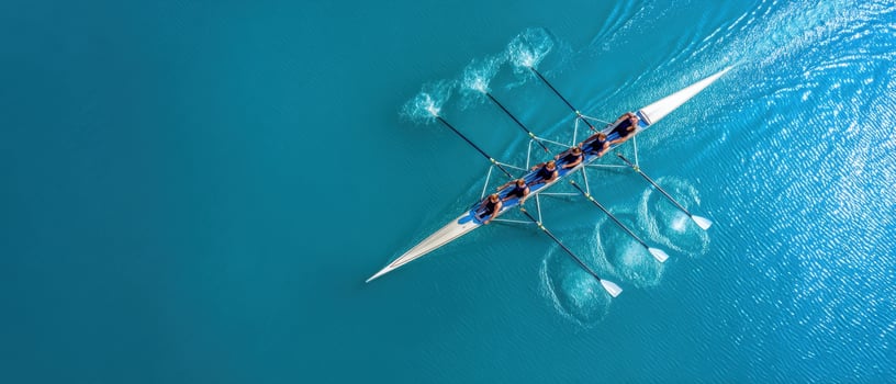 The dynamic team rowing smoothly across vibrant turquoise waters photo