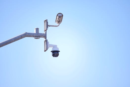 Security camera monitors area under clear blue sky photo