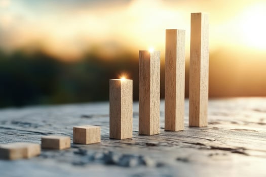 Wooden bar graph with rising blocks showing growth and success in warm sunlight with blurred background photo