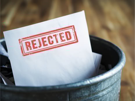 Rejected stamp on paper in metal trash bin concept of failure and discarded document photo