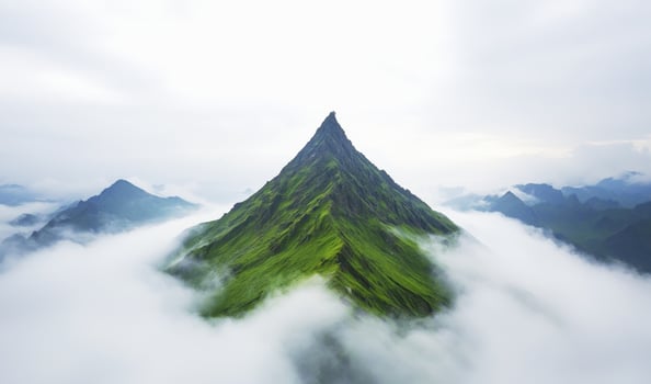 Fog enveloping mountain peak with soft sunlight breaking through clouds creating serene and mystical atmosphere photo