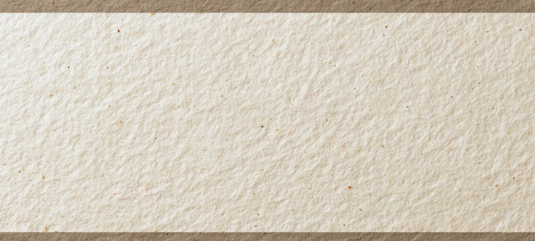 The textured paper background with a natural handmade appearance and rustic elegance. photo