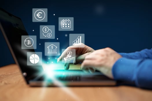 Hands engaged in financial analysis on laptop with digital icons representing currency, graphs, and calendar photo