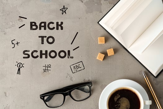 Back to school preparation with coffee, glasses, and open book on a textured surface photo