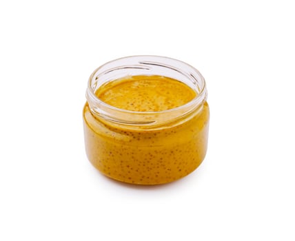 Homemade mustard in a clear glass jar on white background photo
